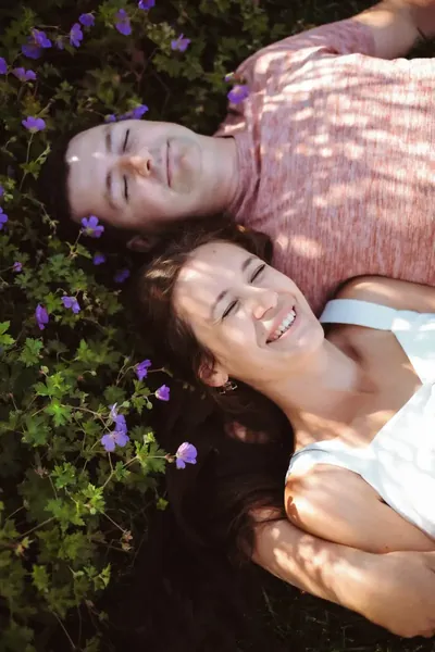O casal deitado na relva florida, enquadramento vertical — Olesia Shelkovenko