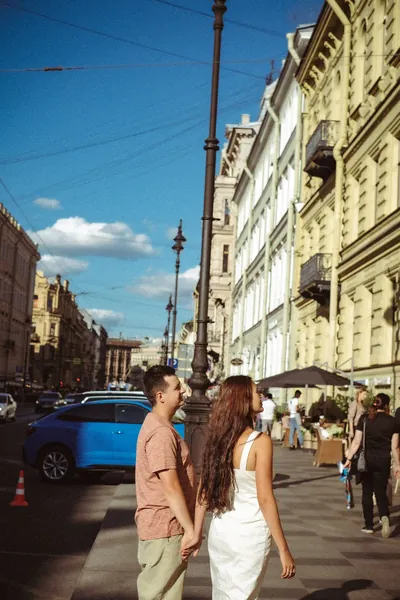 O casal a caminhar pela rua, junto a carros estacionados — Olesia Shelkovenko