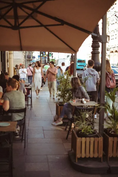 Esplanada de café sob um guarda-sol, mesas e transeuntes — Olesia Shelkovenko