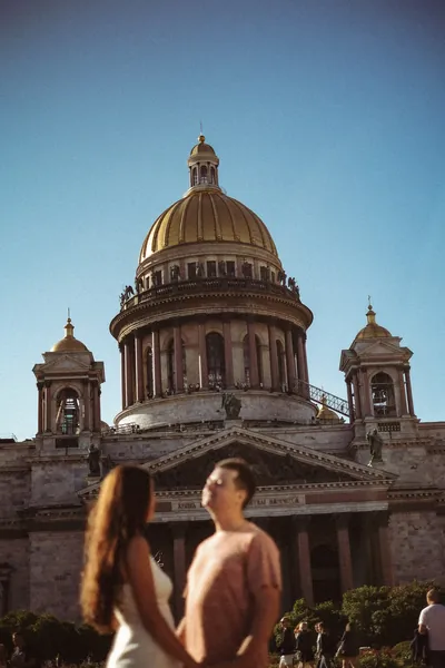 O casal com a cúpula de uma catedral ao fundo — Olesia Shelkovenko