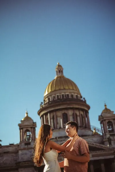 O casal abraçado junto à catedral, com a cúpula no enquadramento — Olesia Shelkovenko